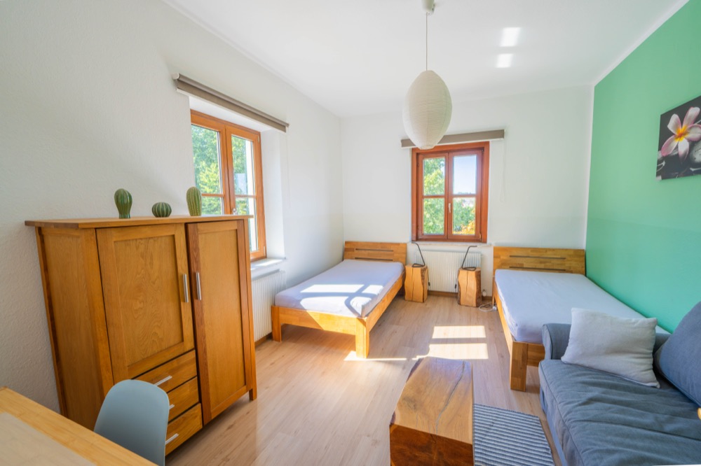 Schlafzimmer mit zwei Betten und Massivholzmöbeln